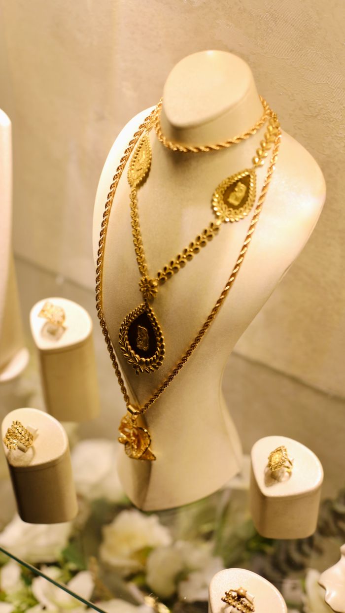 Luxurious gold necklaces and rings displayed elegantly in a jewelry shop in Idlib, Syria.
